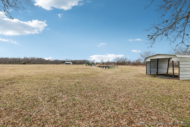 view of yard with a rural view and a carport