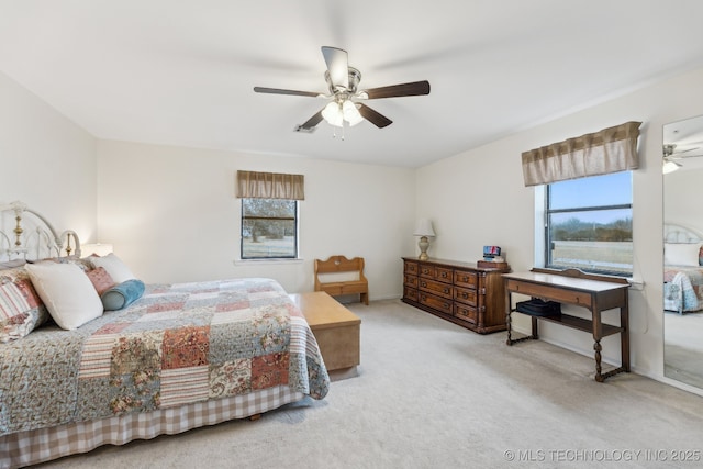 bedroom with ceiling fan, light carpet, and multiple windows