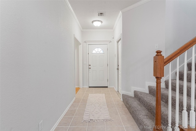 entrance foyer with crown molding and light tile patterned floors