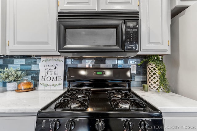 kitchen featuring white cabinetry, decorative backsplash, and black appliances