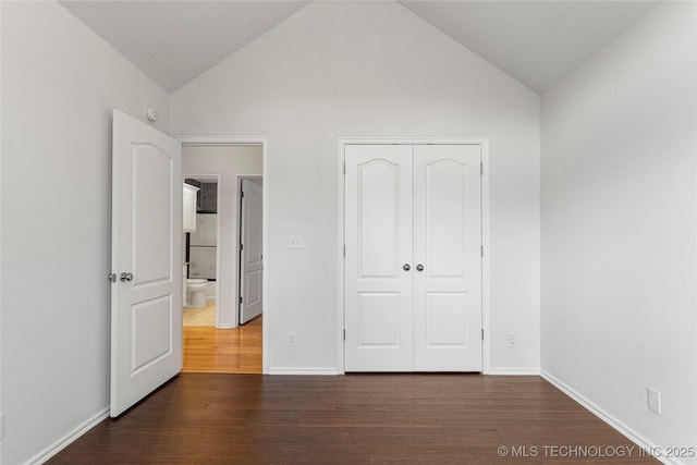 unfurnished bedroom with lofted ceiling, dark hardwood / wood-style floors, and a closet