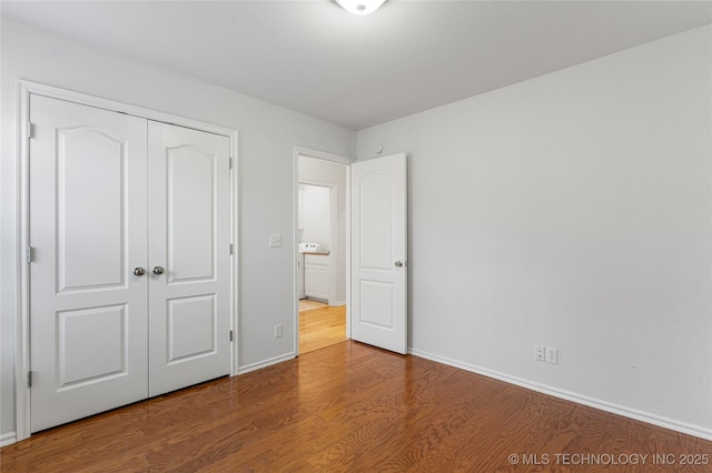 unfurnished bedroom featuring wood-type flooring and a closet