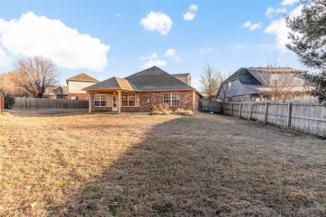 rear view of property with a yard