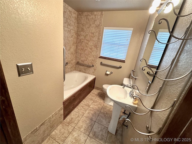 full bathroom with tiled shower / bath combo, sink, tile patterned floors, and toilet