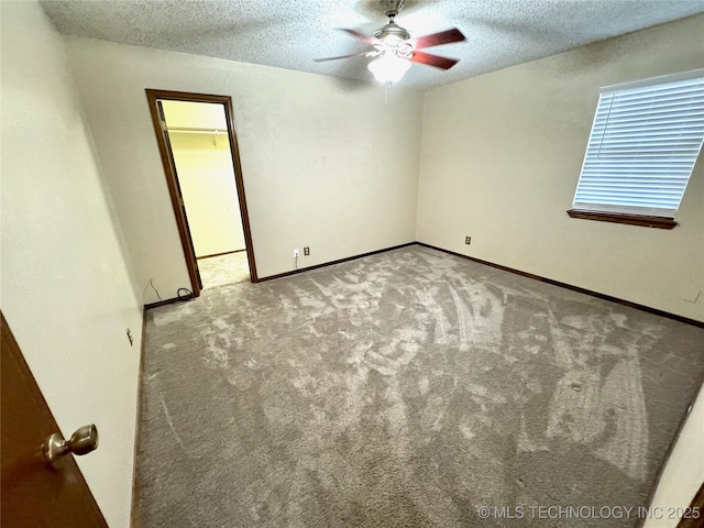 carpeted empty room with ceiling fan and a textured ceiling