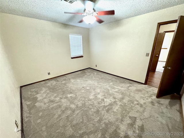 carpeted empty room with ceiling fan and a textured ceiling