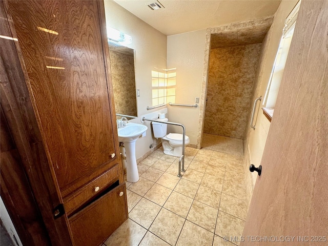 bathroom with sink, a textured ceiling, tile patterned floors, and toilet