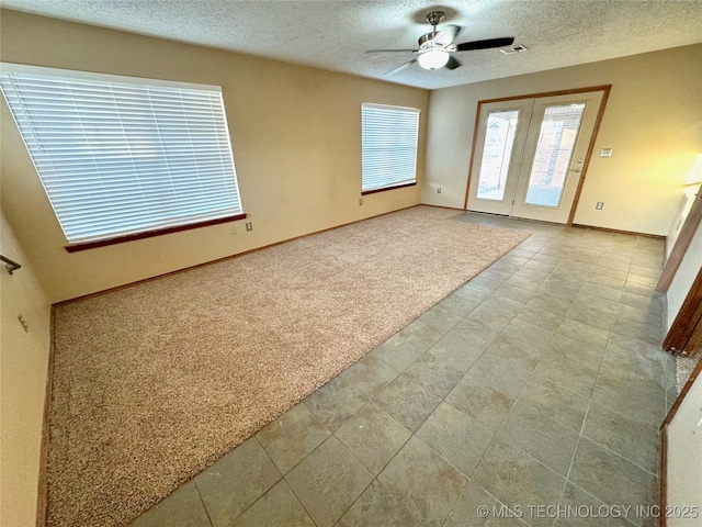 unfurnished room with light carpet, ceiling fan, and a textured ceiling