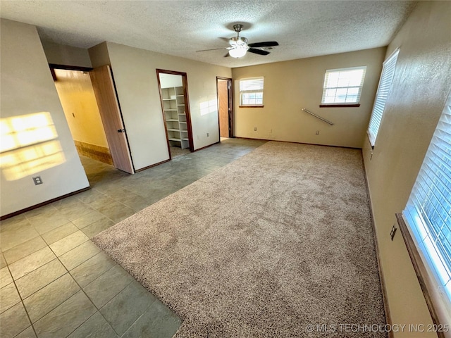 tiled spare room featuring a textured ceiling and ceiling fan