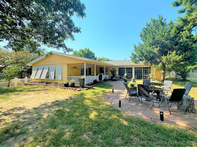 rear view of property featuring a patio and a lawn