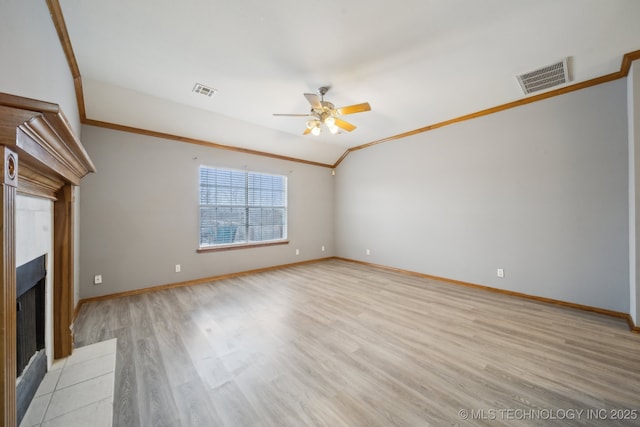 unfurnished living room with ornamental molding, vaulted ceiling, ceiling fan, and light wood-type flooring