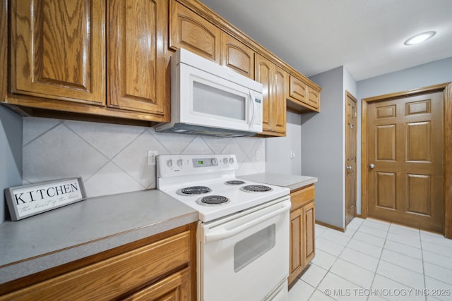 kitchen featuring backsplash, white appliances, and light tile patterned floors