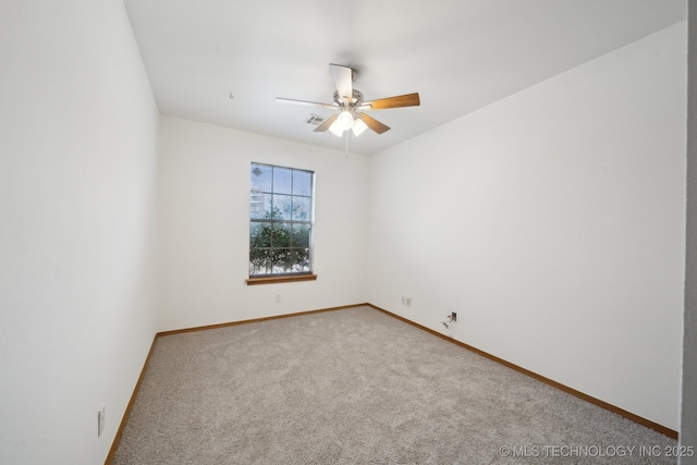 spare room with ceiling fan and carpet