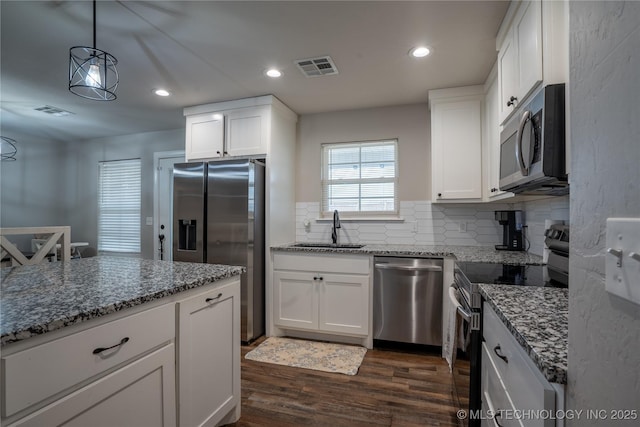 kitchen with sink, stone counters, stainless steel appliances, dark hardwood / wood-style floors, and white cabinets