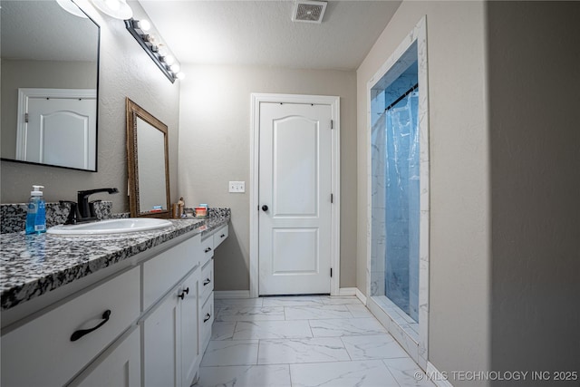 bathroom with vanity, a shower with shower curtain, and a textured ceiling