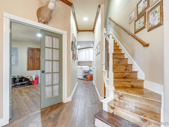 stairway with washing machine and dryer, crown molding, hardwood / wood-style floors, and french doors