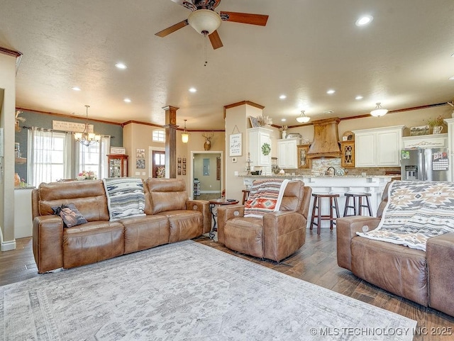 living room with ornamental molding, ceiling fan with notable chandelier, and light hardwood / wood-style flooring