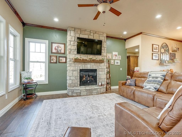 living room featuring crown molding, a fireplace, dark hardwood / wood-style floors, and ceiling fan