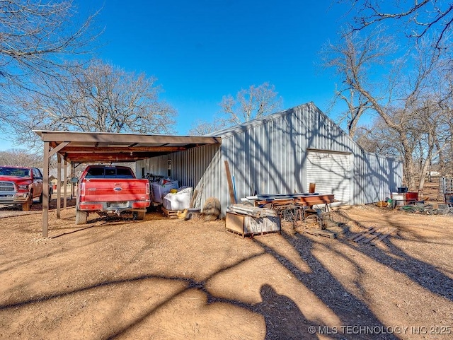 exterior space featuring a garage, an outdoor structure, and a carport