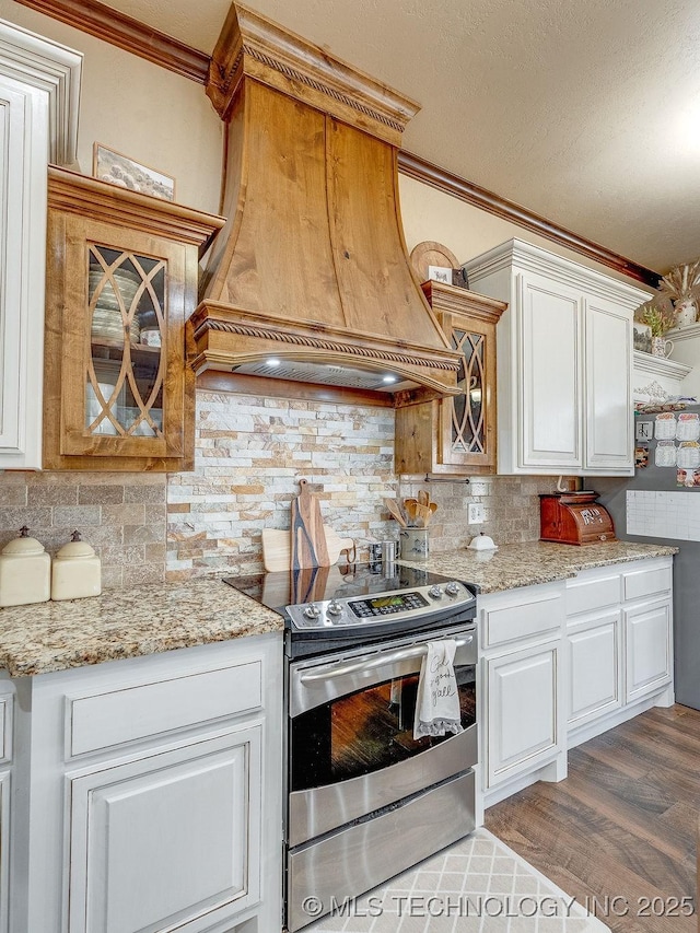 kitchen featuring custom exhaust hood, tasteful backsplash, white cabinetry, stainless steel electric range oven, and dark hardwood / wood-style floors