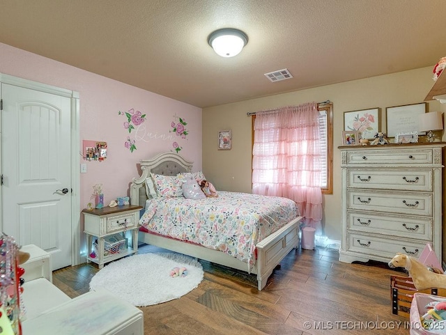 bedroom with dark wood-type flooring and a textured ceiling