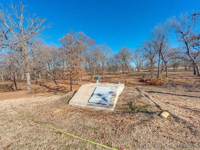 entry to storm shelter featuring a rural view