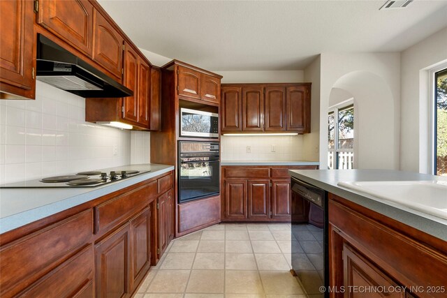 kitchen with light tile patterned flooring, sink, backsplash, and black appliances