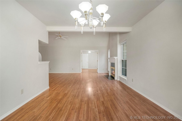 unfurnished living room featuring hardwood / wood-style floors and ceiling fan with notable chandelier