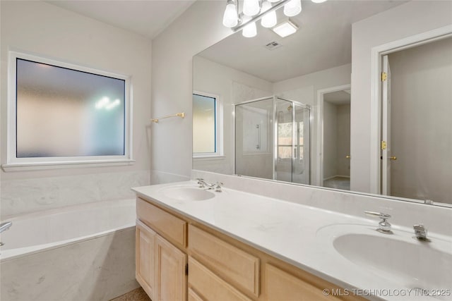 bathroom with vanity and shower with separate bathtub