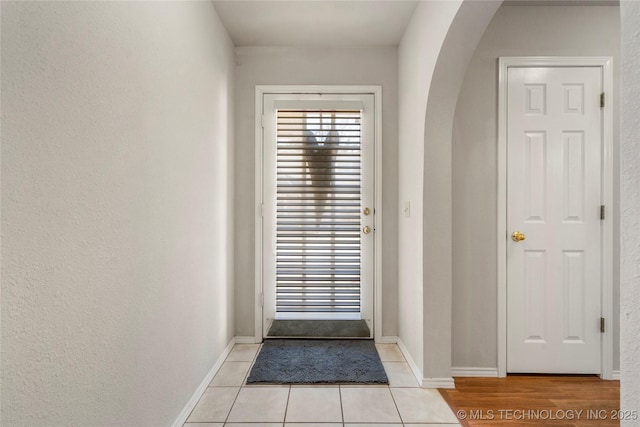 doorway with light tile patterned floors