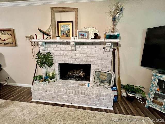 interior details with wood-type flooring, a brick fireplace, and ornamental molding