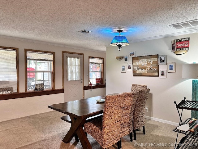 carpeted dining area featuring ornamental molding and a textured ceiling