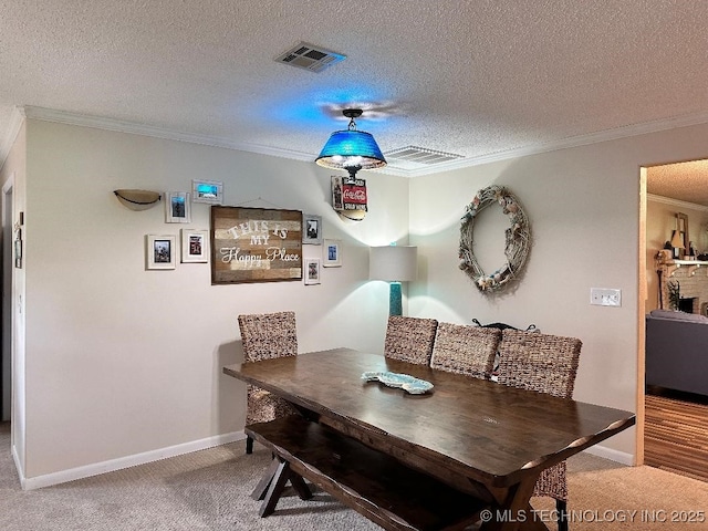 carpeted dining area with ornamental molding and a textured ceiling