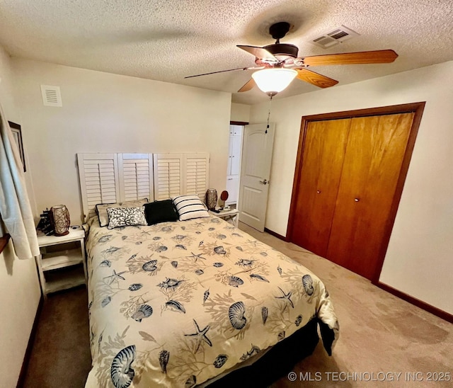 carpeted bedroom featuring ceiling fan, a closet, and a textured ceiling