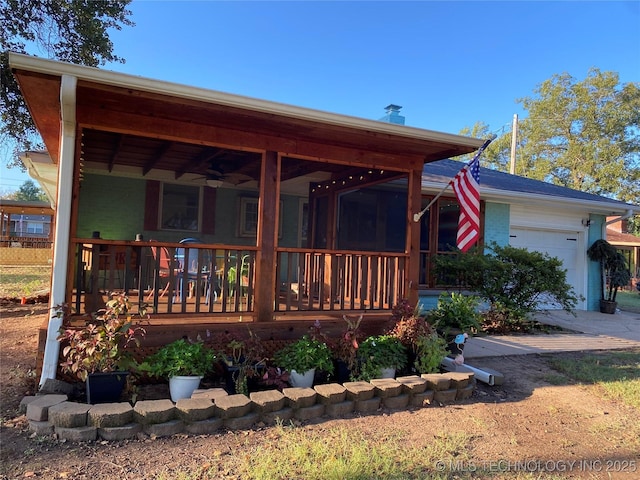 rear view of house featuring a garage and covered porch