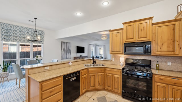 kitchen featuring tasteful backsplash, black appliances, sink, hanging light fixtures, and kitchen peninsula