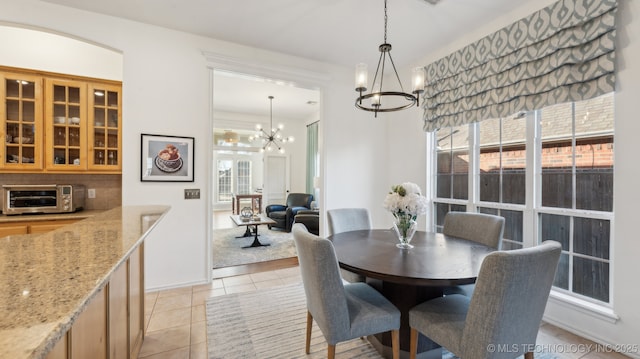 tiled dining space featuring a wealth of natural light and a chandelier