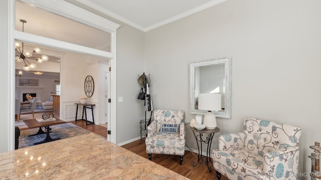 sitting room featuring a notable chandelier, crown molding, and dark wood-type flooring