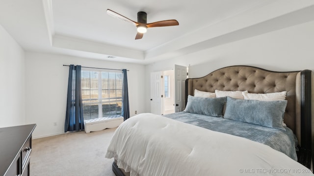 bedroom with light carpet, a raised ceiling, and ceiling fan