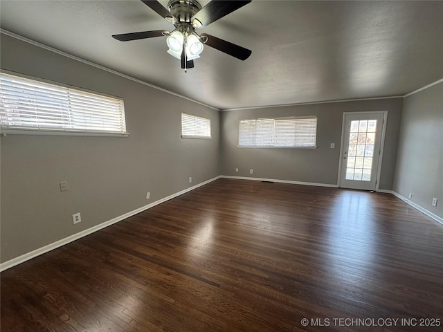 spare room featuring dark hardwood / wood-style flooring, ceiling fan, crown molding, and a healthy amount of sunlight