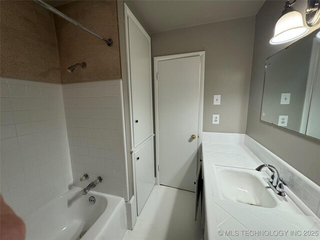 bathroom with vanity and tiled shower / bath