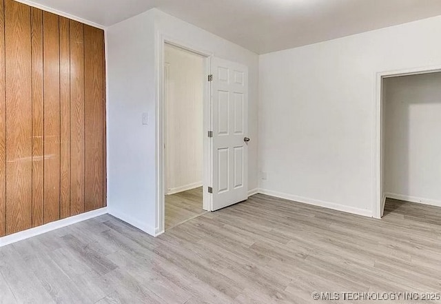 unfurnished bedroom with a closet and light wood-type flooring