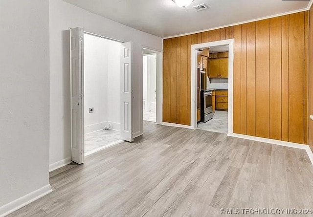 interior space featuring wooden walls and light hardwood / wood-style floors