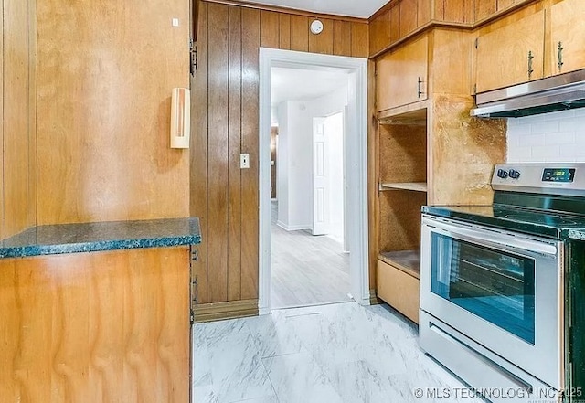 kitchen with wood walls and stainless steel electric range oven