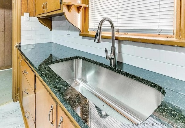 details featuring tasteful backsplash and sink