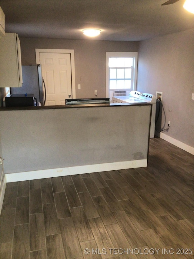 kitchen with stainless steel fridge, dark wood-type flooring, washing machine and clothes dryer, and ceiling fan