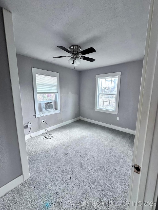 carpeted spare room with cooling unit, ceiling fan, and a textured ceiling