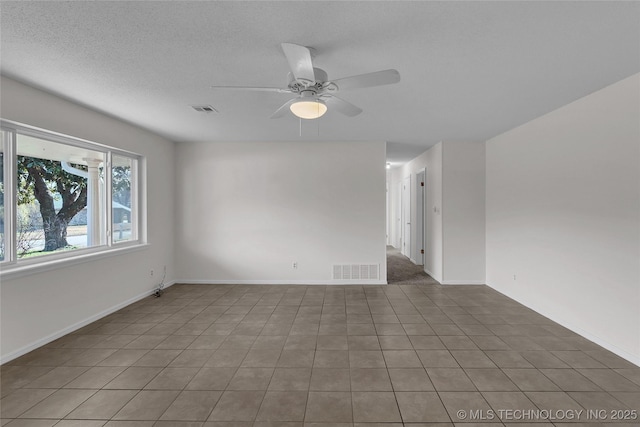 tiled spare room with a textured ceiling and ceiling fan