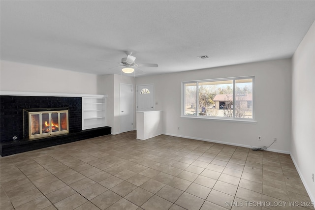 unfurnished living room featuring ceiling fan, a brick fireplace, and light tile patterned floors