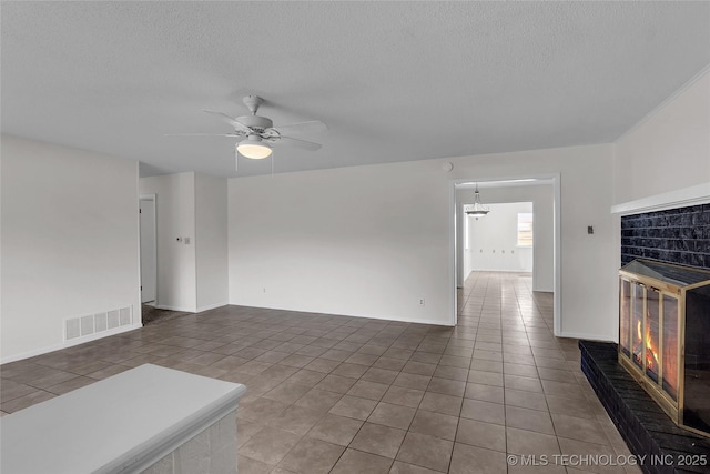 unfurnished living room with a textured ceiling, tile patterned floors, and ceiling fan